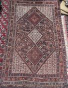 A red ground rug with a central medallion comprising smaller medallions and multiple guard stripes,