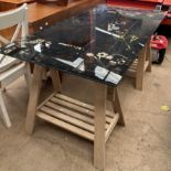 A glass topped desk with easel legs