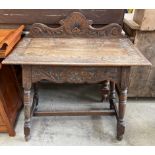 A 20th century oak side table with a raised back and rectangular top on turned legs