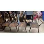 A set of four Ercol stick back dining chairs on tapering legs,