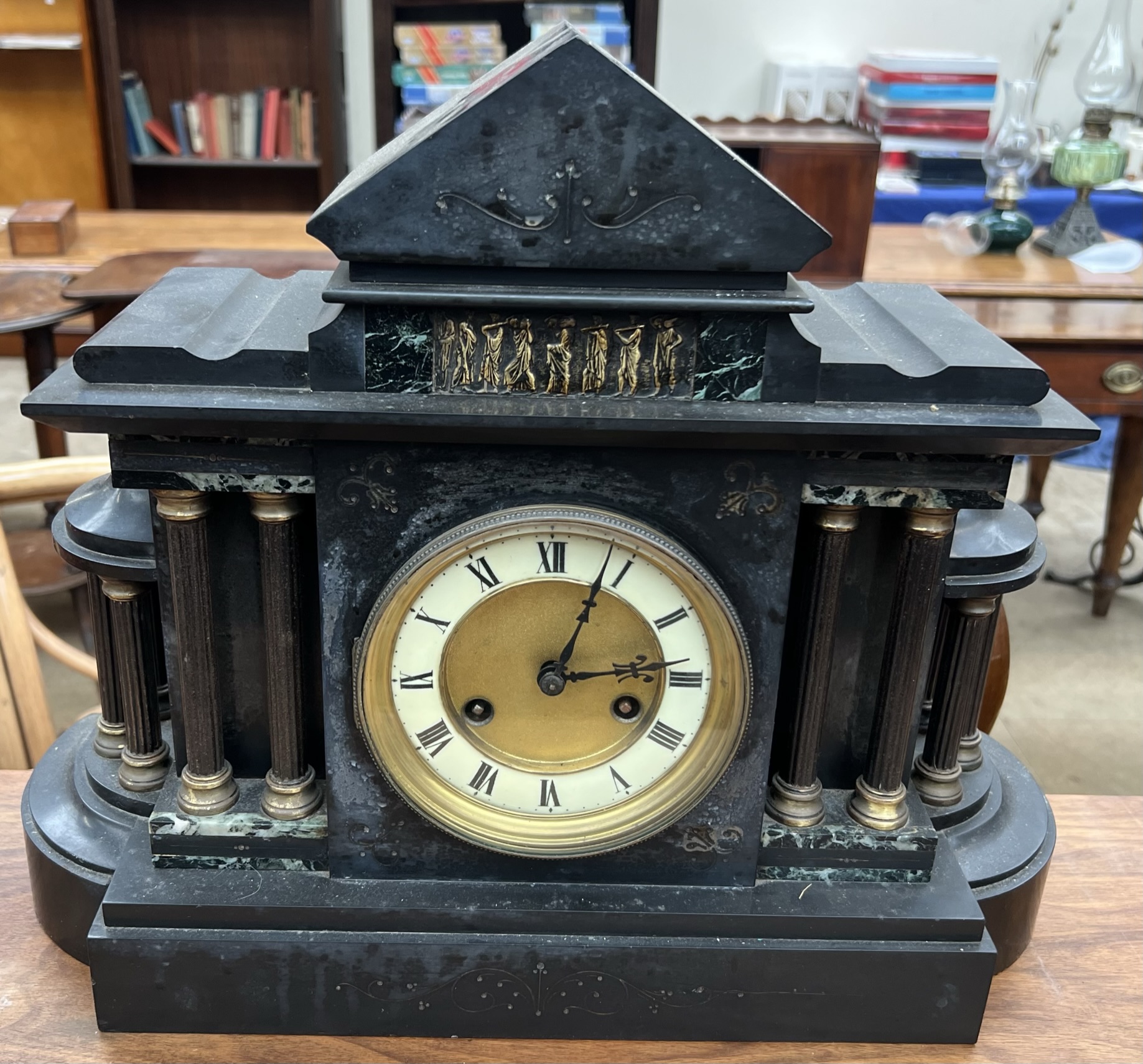 A black slate mantle clock of architectural form,