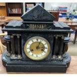 A black slate mantle clock of architectural form,