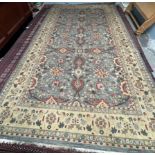 A large room size rug, with a blue ground and interlaced flowers and leaves,