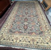 A large room size rug, with a blue ground and interlaced flowers and leaves,
