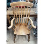 A slat back kitchen chair with a solid seat on turned legs