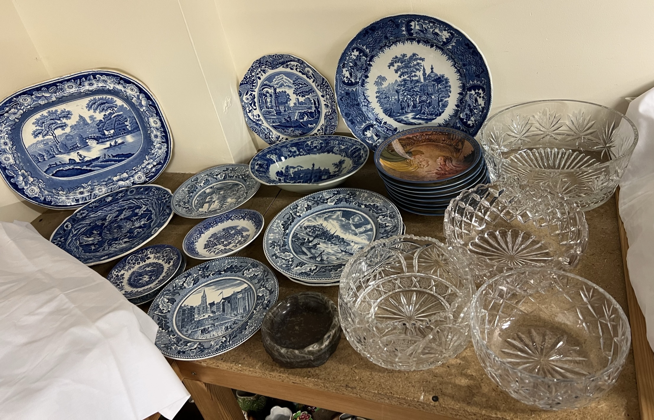 A blue and white pottery meat plate with a river scene together with a collection of blue and white
