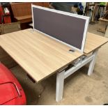 A back to back height adjustable electrical desk, with central screen, 140cm wide x 168.