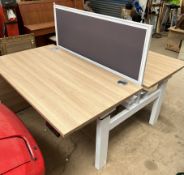 A back to back height adjustable electrical desk, with central screen, 140cm wide x 168.