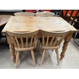 A pine kitchen table together with a set of four pine kitchen chairs