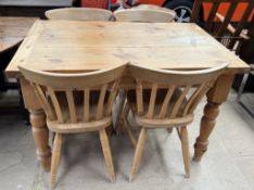 A pine kitchen table together with a set of four pine kitchen chairs