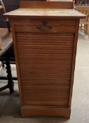 An oak tambour fronted filing cabinet with a drop front and sliding drawers, 50.