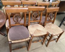 A set of six dining chairs with a bar back and roundel with floral centre and a rush seat on