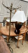 A brass coat and stick stand together with a table lamp