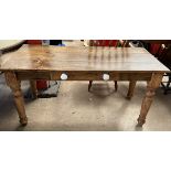 A Victorian pine table with a planked rectangular top above a frieze drawer on turned tapering legs,