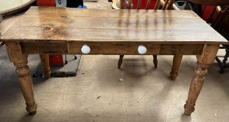 A Victorian pine table with a planked rectangular top above a frieze drawer on turned tapering legs,