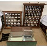A collection of porcelain thimbles contained in two glass fronted cabinets together with another