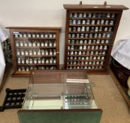 A collection of porcelain thimbles contained in two glass fronted cabinets together with another