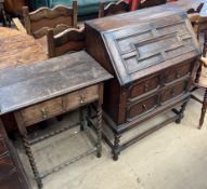 A 20th century oak bureau with a geometric panelled sloping fall above two drawers on barley twist