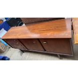 A mid 20th century walnut sideboard with a rectangular top above four drawers and two cupboards on