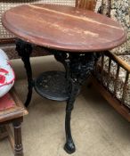 A pub table with a circular top and cast iron base with figure head terminals