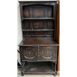 A 20th century oak dresser with a moulded cornice, two shelves and an enclosed back,