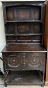 A 20th century oak dresser with a moulded cornice, two shelves and an enclosed back,