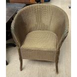 A Lloyd Loom elbow chair painted gold