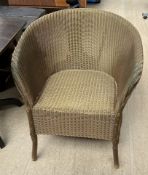 A Lloyd Loom elbow chair painted gold