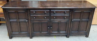 A 20th century oak sideboard with four drawers and four cupboards on square legs,