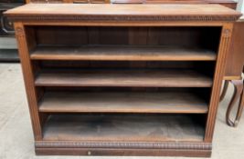 A late 19th century oak bookcase with a rectangular top and carved frieze above three shelves on a