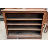 A late 19th century oak bookcase with a rectangular top and carved frieze above three shelves on a
