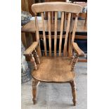 A slat back kitchen chair with a solid seat on turned legs