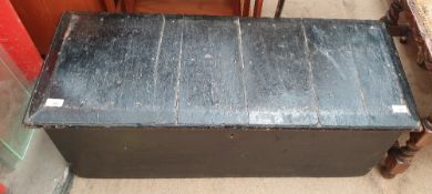 A black painted coffer with wrought iron carrying handles,