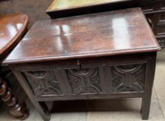 An 18th century style oak coffer with a planked rectangular top and a carved front on stiles