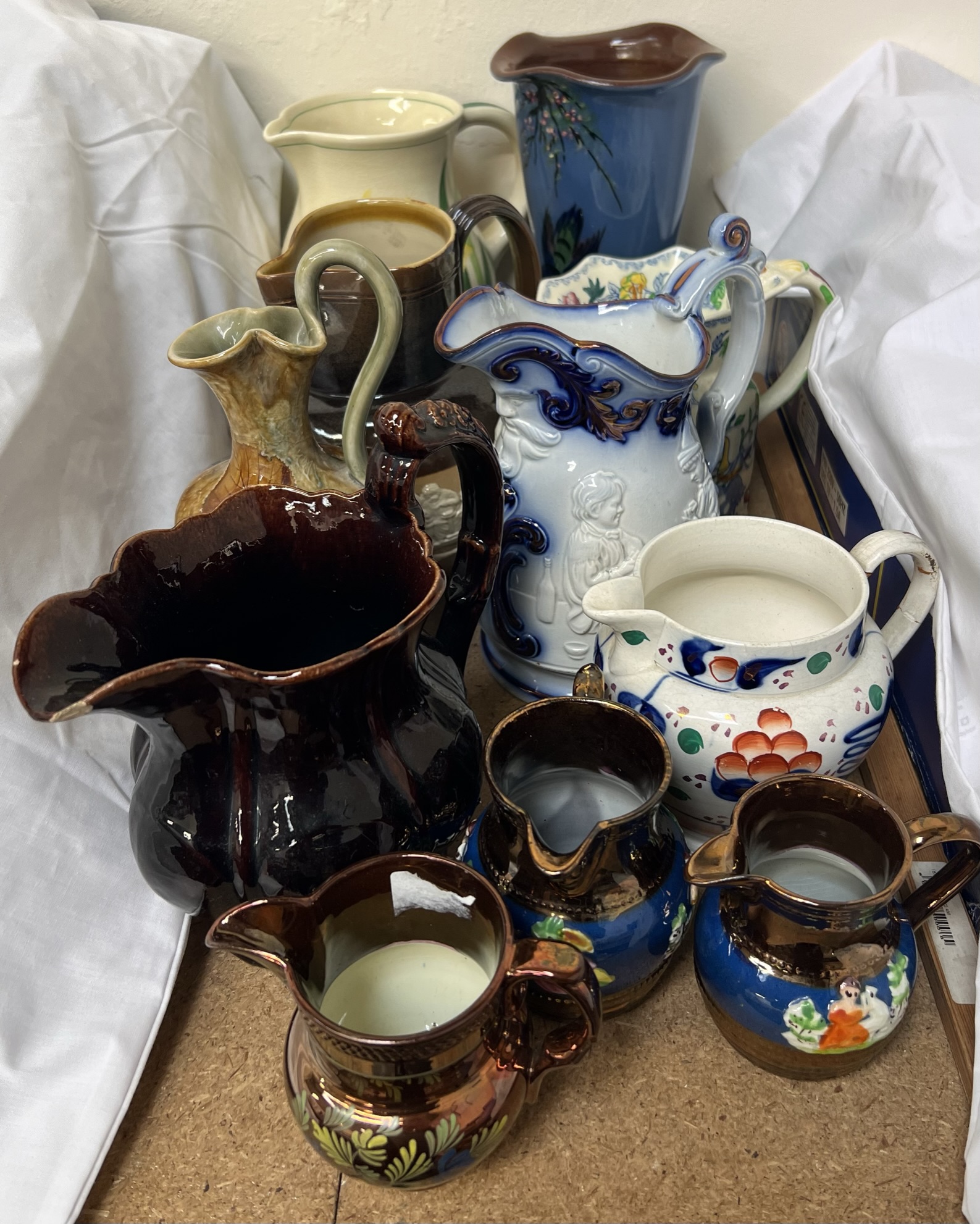 A Royal Doulton leaf moulded ewer together with a Royal Doulton Harvest ware jug and other jugs