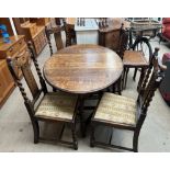 A 20th century oak gateleg dining table on barley twist legs together with a set of four oak dining