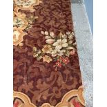 A large Aubusson type carpet with a central medallion with a rose roundel with floral and leaf