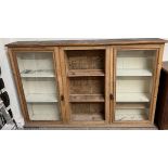 A 19th century pine dresser top with a moulded cornice above a pair of glazed doors and central