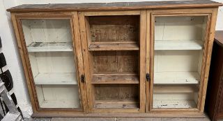 A 19th century pine dresser top with a moulded cornice above a pair of glazed doors and central