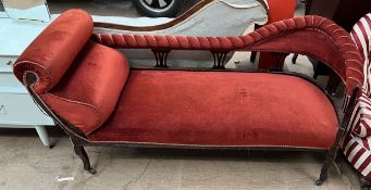 An Edwardian upholstered chaise longue with a pad upholstered back and seats on shaped legs
