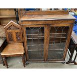 An oak bookcase together with a carved hall chair