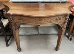 A Regency style side table with a shaped top above a central drawer and four drawers on square