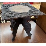 An Anglo Indian table of shaped rectangular form carved with flowers and leaves on a folding base