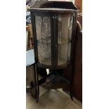 An Edwardian mahogany standing corner display cabinet with a pair of glazed doors on square legs