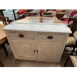 A white painted pine dresser base with two drawers and two cupboards on a plinth