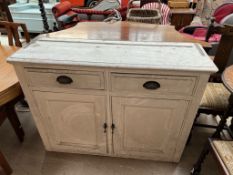 A white painted pine dresser base with two drawers and two cupboards on a plinth