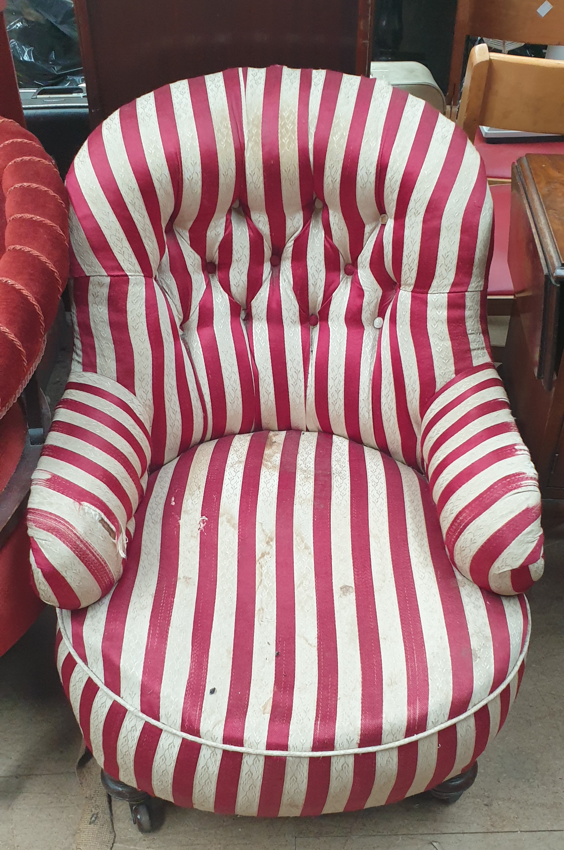 A Victorian nursing chair with a striped fabric on turned legs and casters together with a walnut