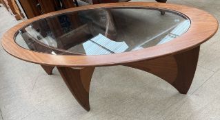 A G-Plan teak coffee table of oval form with an inset glass panel