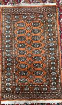 A small Turkoman rug with an orange ground and multiple guls,