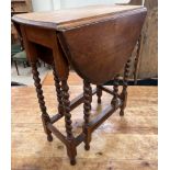 A small oak gateleg table with an oval top and drop flaps on barley twist legs and pad feet